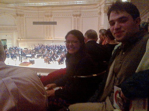 Yalies in their seats at Carnegie hall, with the stage in the background.