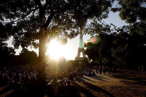 Dense crowds in a park near the Eiffel Tower.