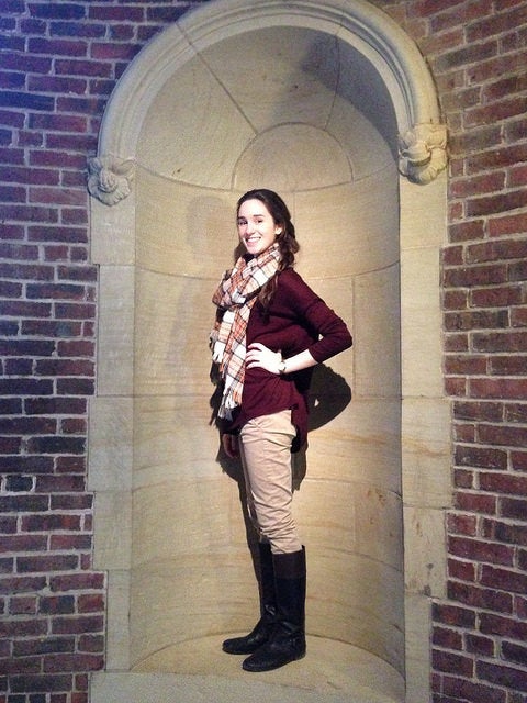 Author Hallie poses like a statue in a wall niche.