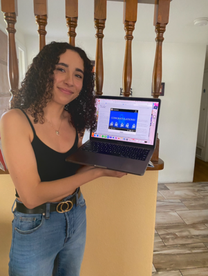 A girl holding a laptop open with a congratulations screen displayed