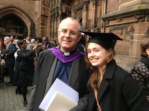 Stephanie in England with her dad after his graduation, wearing his mortarboard.