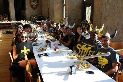 Stilesians in medieval garb sit at a long table for their renaissance-themed dinner.