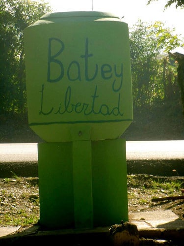 A small structure with &quot;Batey Libertad&quot; hand-painted on its surface.