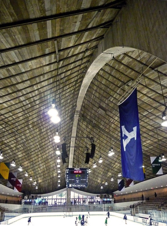 The interior of Ingalls rink, with hockey players practicing on the ice.