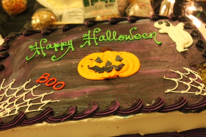 A chocolate cake for Halloween, with a jack-o-lantern and cobwebs drawn in icing.