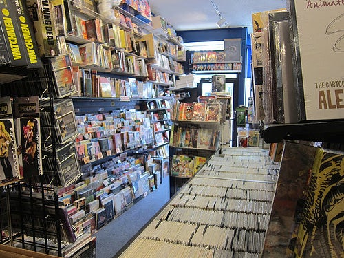 Shelves stocked with comic books, graphic novels and other merchandise.