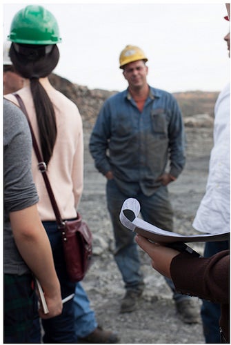 A mine worker giving a tour of the work site.