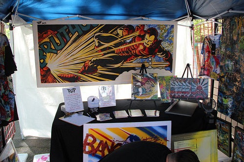 RZP's booth at the open market, featuring a painting of Iron Man in a retro comic book style.