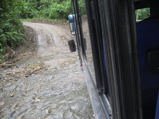 A bus driving across a flooded roadway.