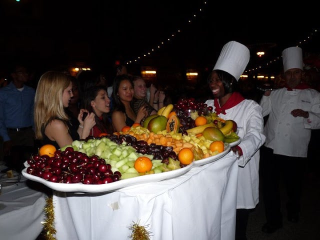 A Yale Dining chef pushing a tray piled with fruit during the &quot;Parade of Comestibles&quot;.