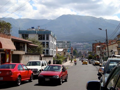 A city street in Quito, with the mountains in the distance.