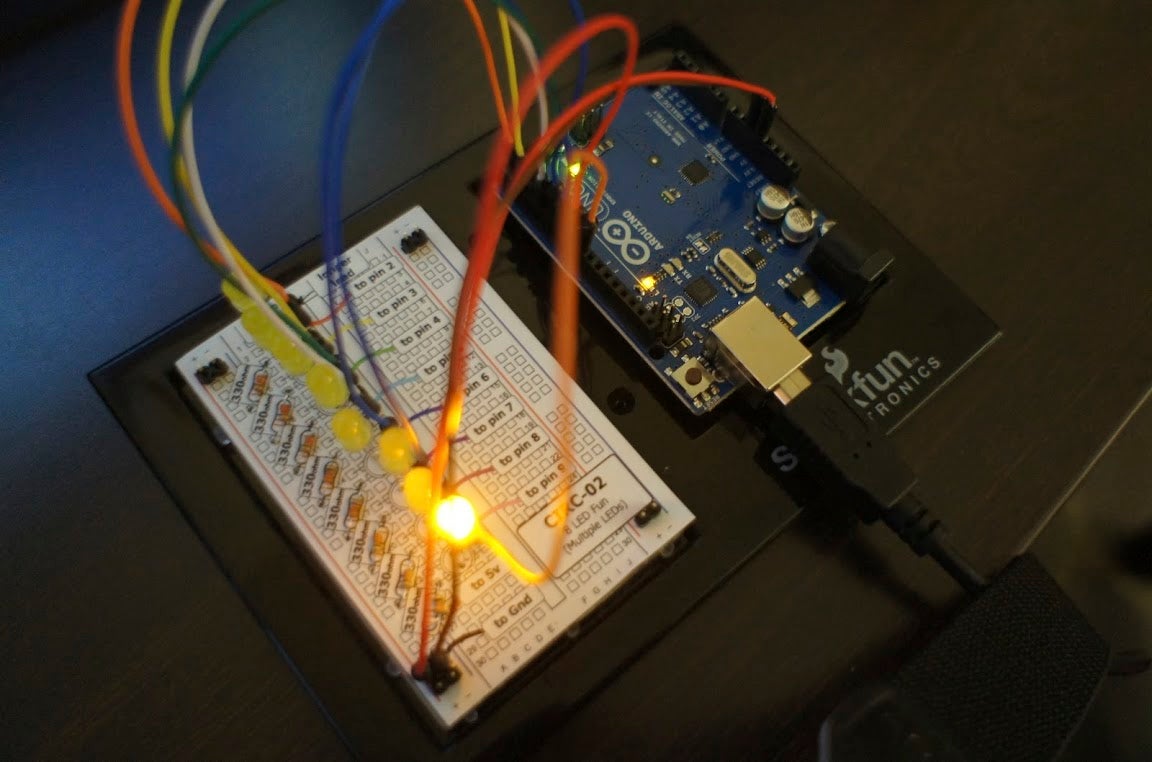 A circuit board with LED lights connected to an Arduino controller with several wires.