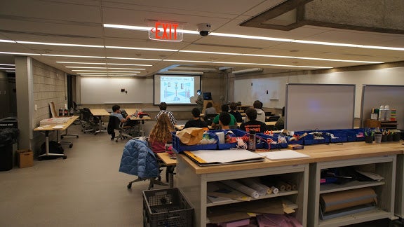 A person giving a slideshow presentation to a group of their peers.