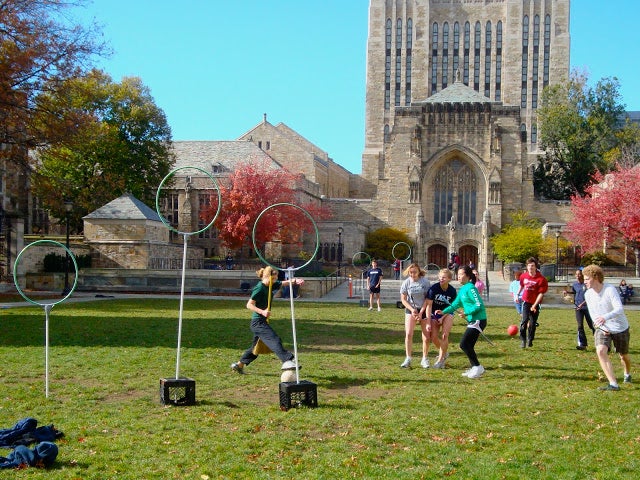 The Quidditch team playing in front of Sterling Memorial Library.
