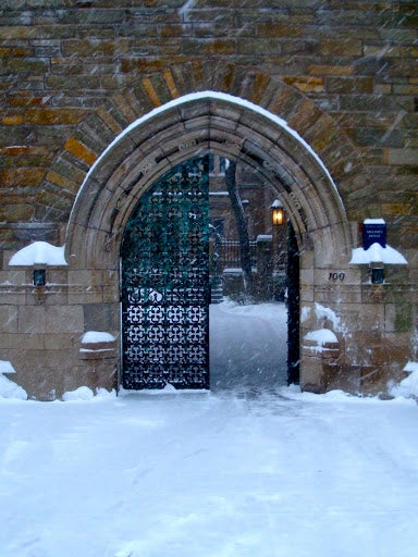 Snow covers the path through a residential college gate.