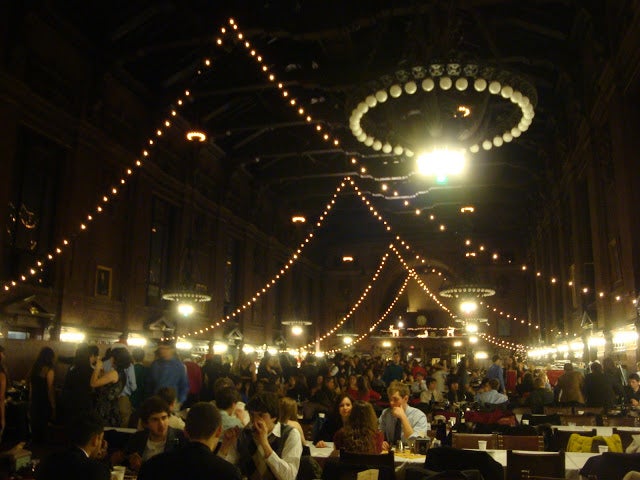 The Yale Commons dining hall strung up with holiday lights and packed with Freshmen.