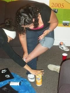 A student wiping paint off her foot with a clorox wipe.