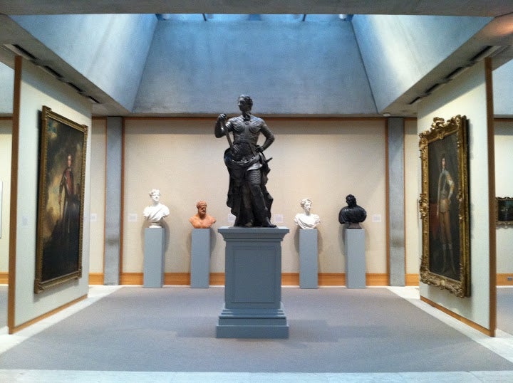 A wing in the Yale University Art Gallery, with famous portraits, a collection of Busts, and a Statue.