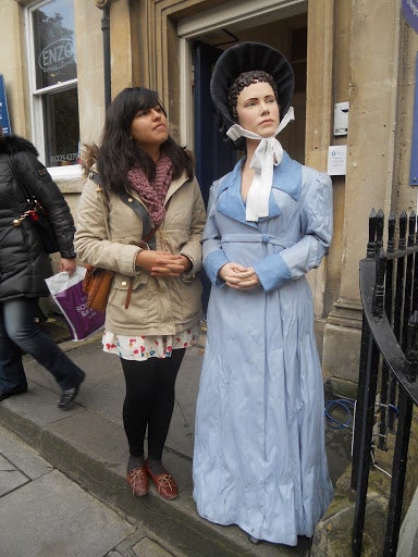 Michelle with a statue of Jane Austen, imitating her dignified pose.