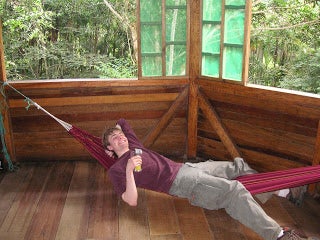 A male student lounging in a hammock.
