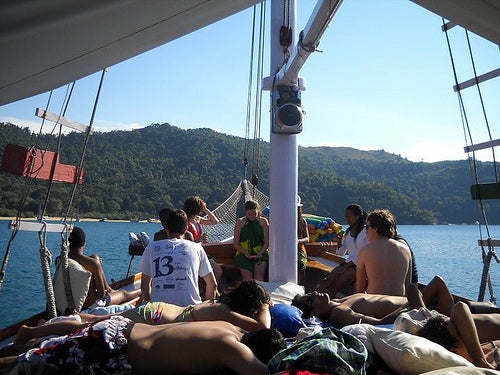 Students sunbathing on the deck of a boat.