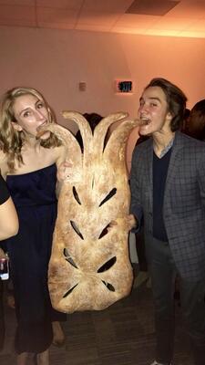 two people eating a GIANT piece of bread 