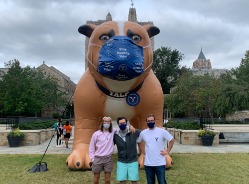 Three students in front of a giant bulldog inflatable