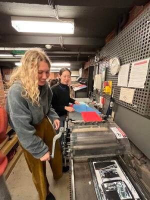 Teamwork between students using rolling printing press