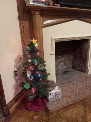 mini christmas tree next to a fireplace