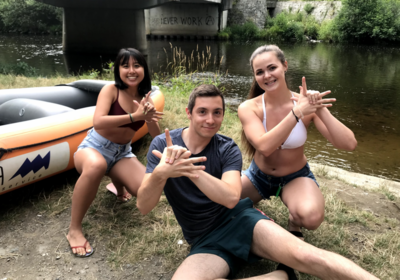 3 people pose in front of a river