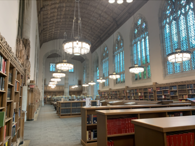 A large library with bookcases and chandeliers 