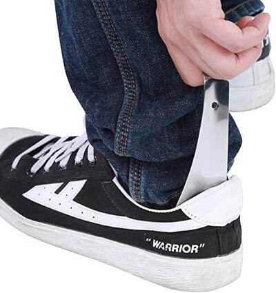 Person using shoe horn to put on sneakers