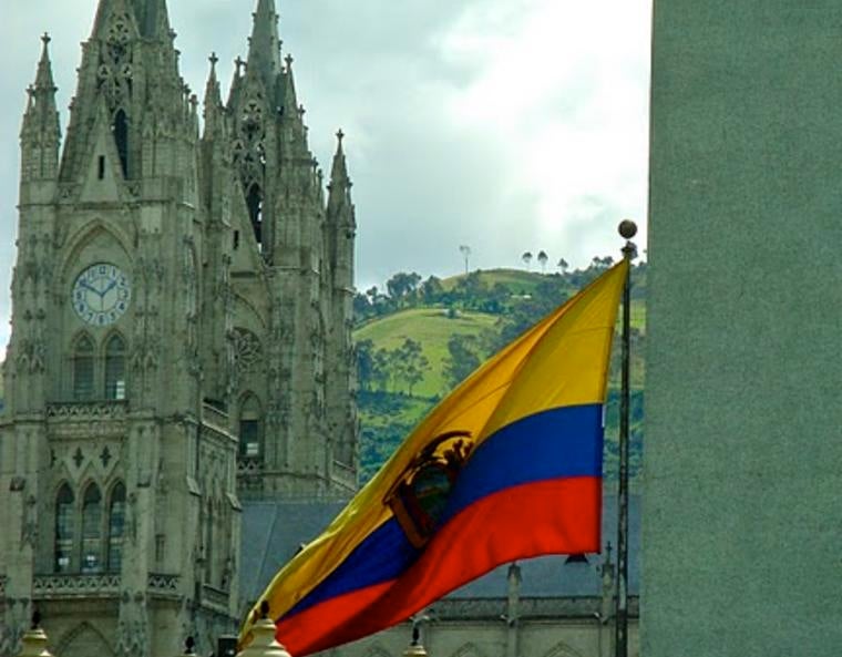 The flag of Ecuador flapping in the wind in front of the Basílica del Voto Nacional in Quito.
