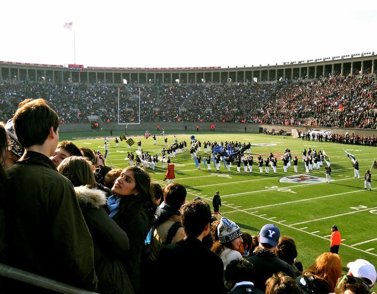 The marching band performing to a packed stadium on the Yale Bowl football field.