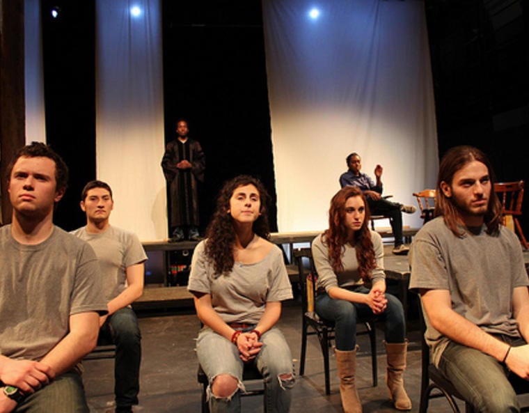 Grim-faced actors on stage in a production of "The Laramie Project"
