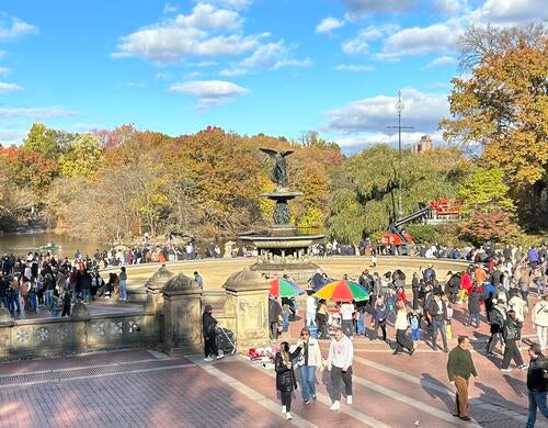 A bustling, sunny day at the Bethesda Fountain in NYC's Central Park
